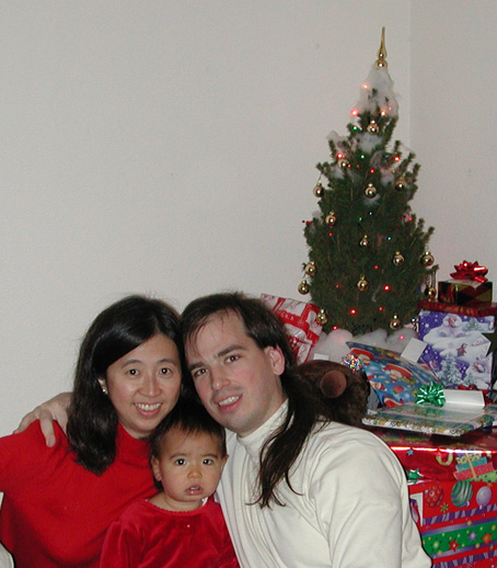 Rebecca, Maya, and Mark by the Christmas tree
